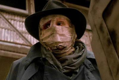 Darkman with face covering and hat looks on