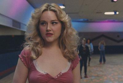 SLUT young woman roller skates in a roller rink.