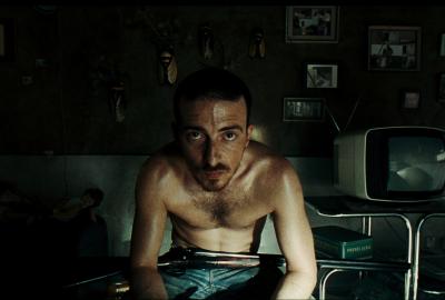 Ale sits with a rifle on his lap