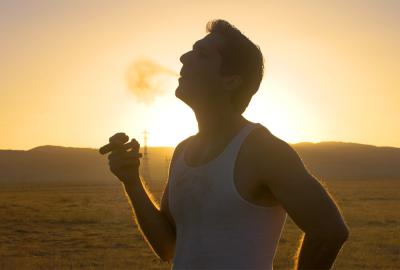 A man smokes a cigar in the desert