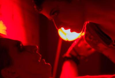 A woman leans over a man