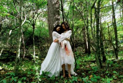 Two women with bloody white dresses hug