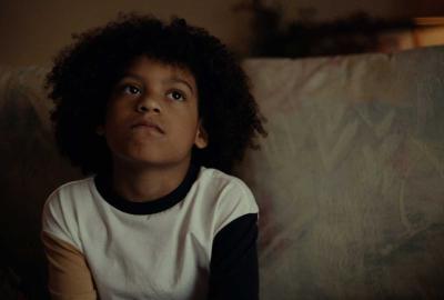 Young boy sits on sofa