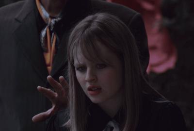 Woman (Lulu Wilson) processing a feeling of a looming hand of a man standing behind her.