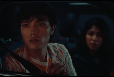 A man and woman look out the car window