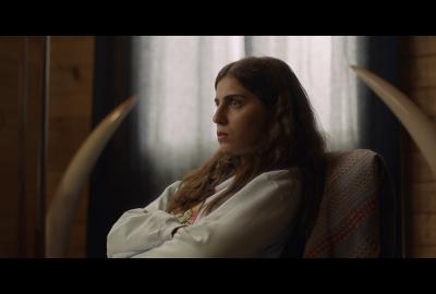 A woman with her arms crossed looks on