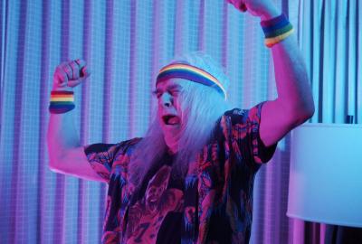 An older man with arms up in the air 