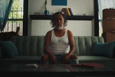 Man sitting on couch, staring at us