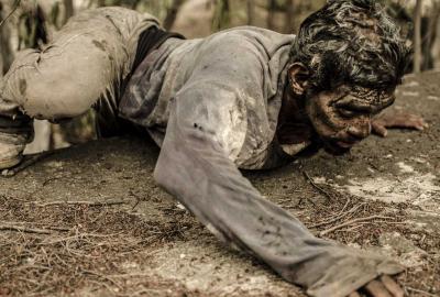 A man crawls on the ground