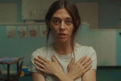 A woman crosses her arms on her chest and looks on