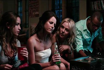 Needle woman sitting on a couch drinking and talking at a party