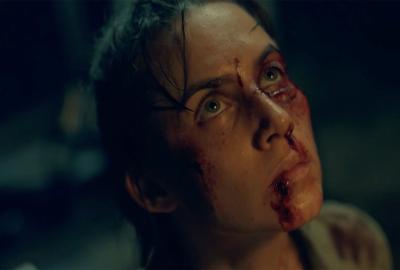 A bloody faced woman looks up