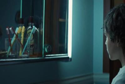 A boy looks in the bathroom mirror